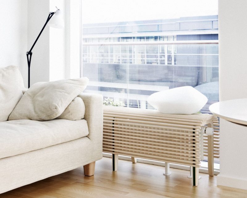 Interior of a living room with a hinged screen on a heating battery