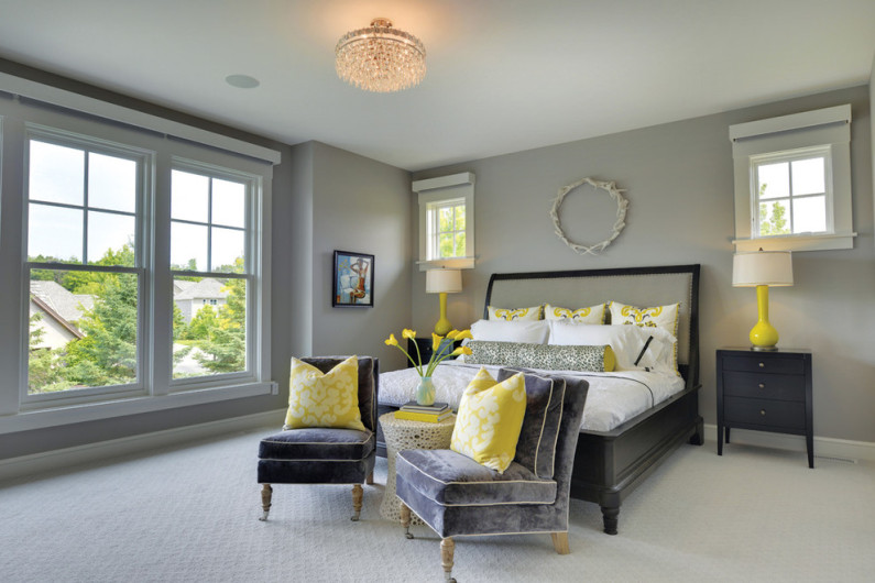 Yellow decorative pillows in the interior of a gray bedroom