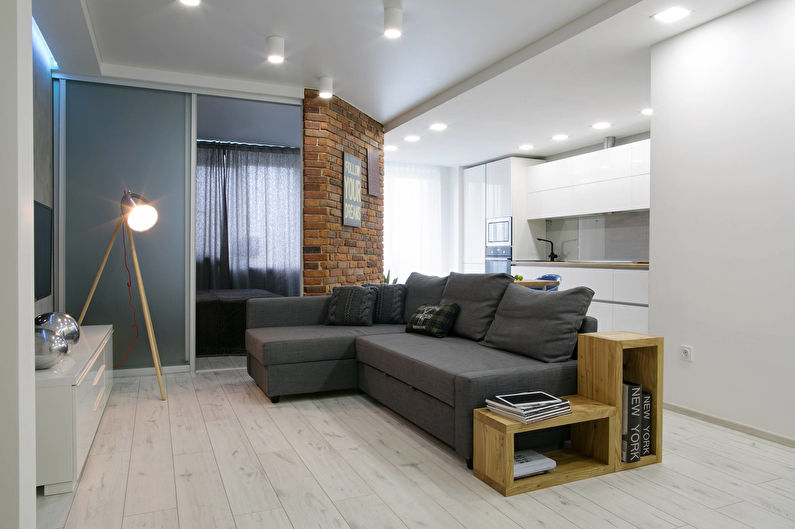 White walls in the hall with a dark gray sofa