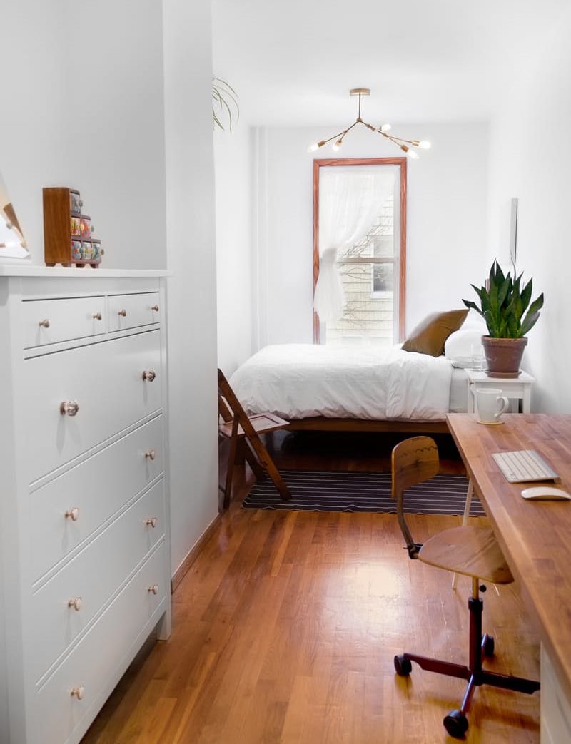 Table brune dans la chambre aux murs blancs