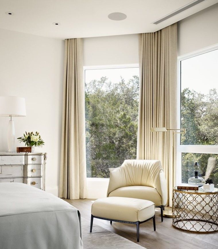 Tall bedroom windows with beige curtains