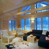 Black sofa in the living room of a house made of timber