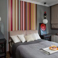 Narrow striped wallpaper over the head of the bed