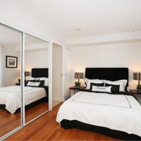 Zrcalni zid u spavaćoj sobi s bijelim krevetom