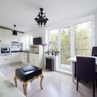 Black chandelier on the white ceiling of a spacious room