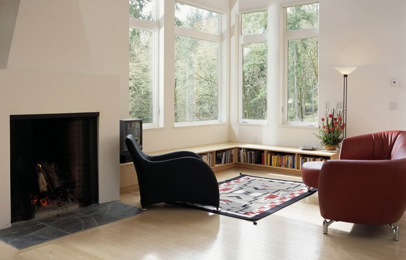 Two leather chairs in front of the windows in the corner of the living room