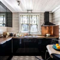 Kuhinja s crnim namještajem u drvenoj kući