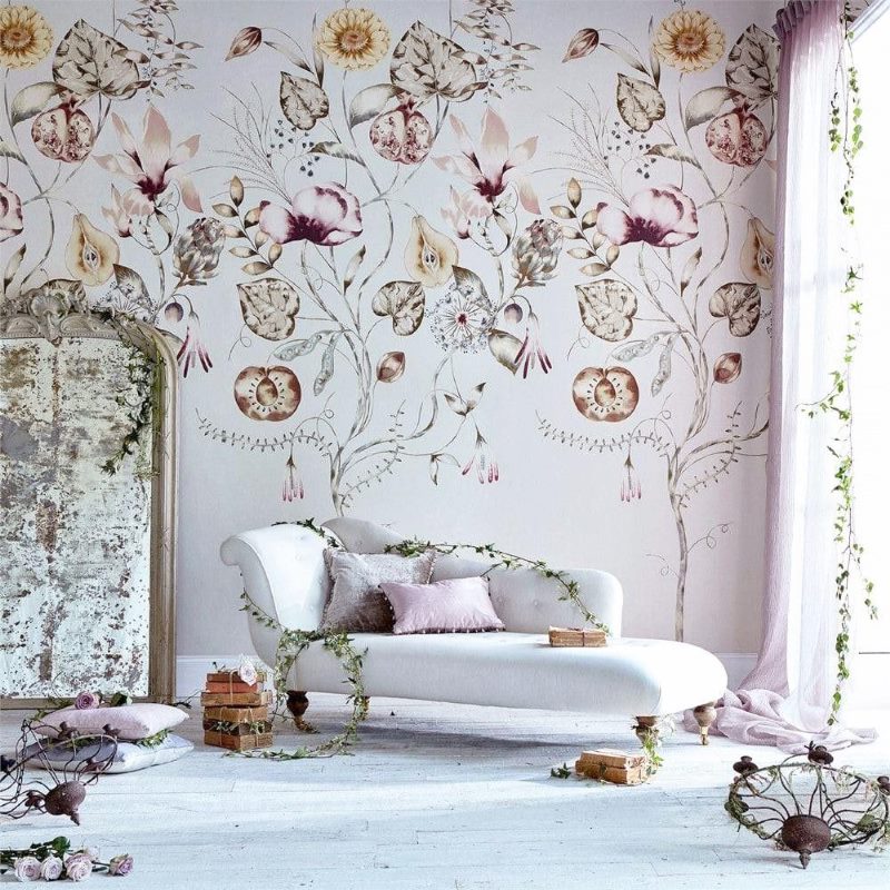 Bright wallpaper with floral ornaments behind a white sofa