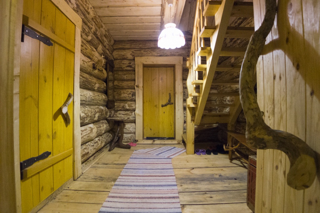 Interior of an entrance hall with a staircase in a log house