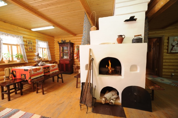 Russian stove with white trim in the interior of the living room of a private house