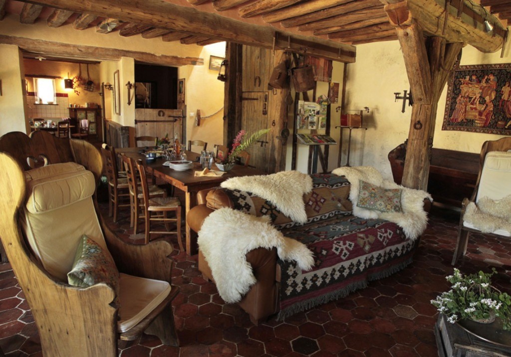 White animal skins on a sofa in a living room of a wooden house