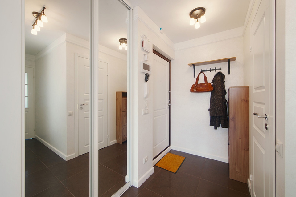 Armoire coulissante avec miroirs dans un couloir blanc