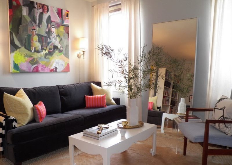 Floor mirror in the interior of the living room with two windows