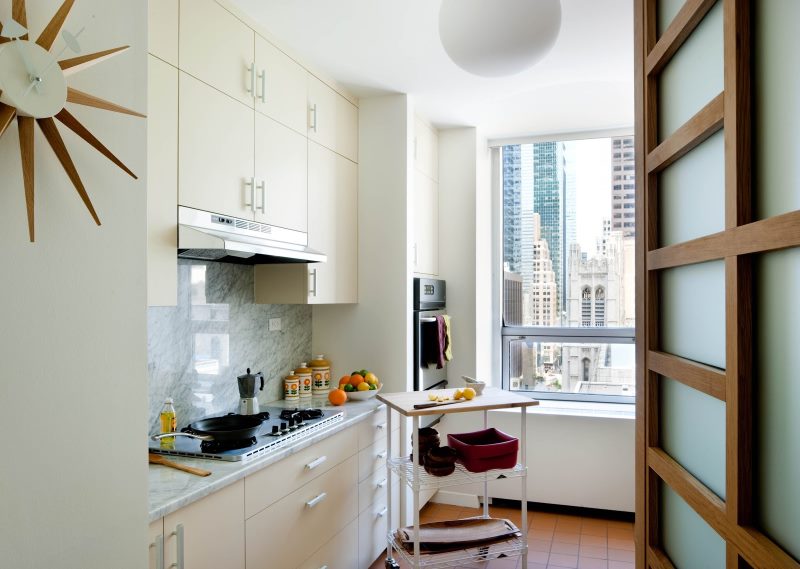 Open door to a white linear kitchen