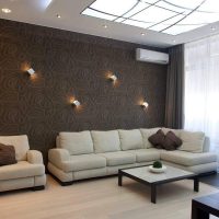 Sofa beige di dalam bilik dengan kertas dinding berwarna coklat