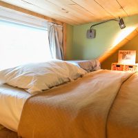 Chambre avec plafond bas dans les combles d'une maison de campagne