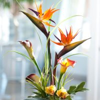 Staklena čaša s umjetnim cvjetovima