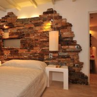 Decorazione con muro di pietra artificiale sopra il letto