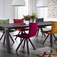 Upholstered chairs of different colors in the dining room-kitchen of a private house