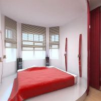 Red bedspread on the bed in a white bedroom