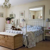 Wooden chest in front of a bed with a forged frame