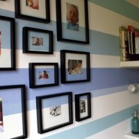 Black frames and photo on the striped wall.