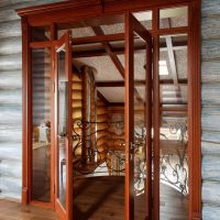 Wooden doors with glass in a log wall