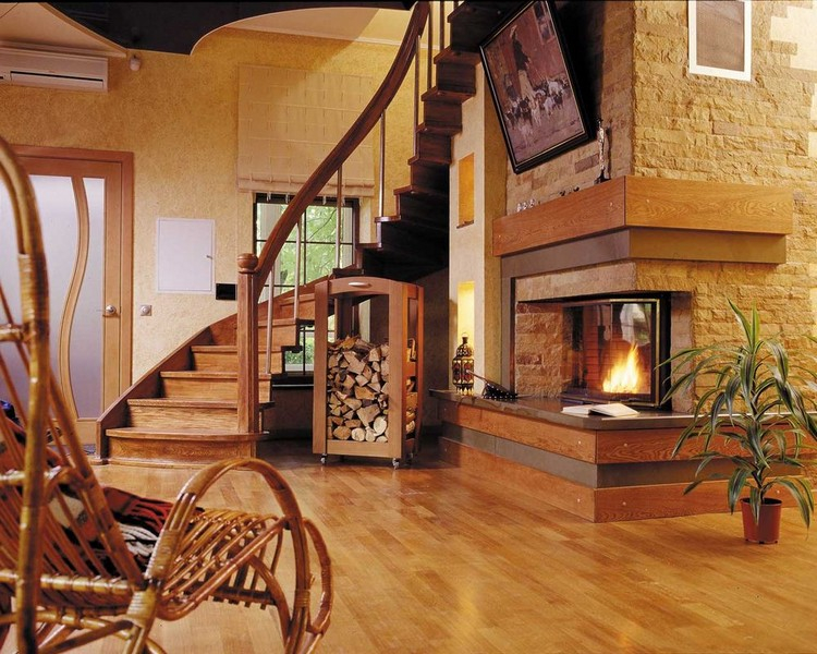 Interijer dnevnog boravka sa kaminom i stepenicama u drvenoj kući