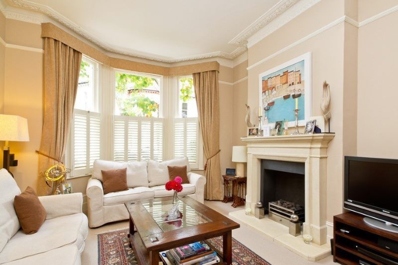 Fireplace in the living room of a three-room apartment with a bay window