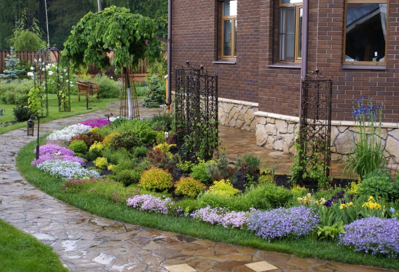 The design of the flower bed in front of the windows of a country house