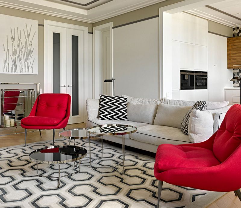 Dvije crvene stolice na tepihu s geometrijskim uzorkom