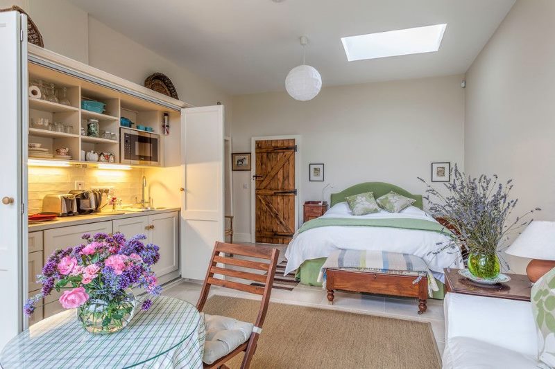 Interior of an apartment with a kitchen and a bedroom in a common room