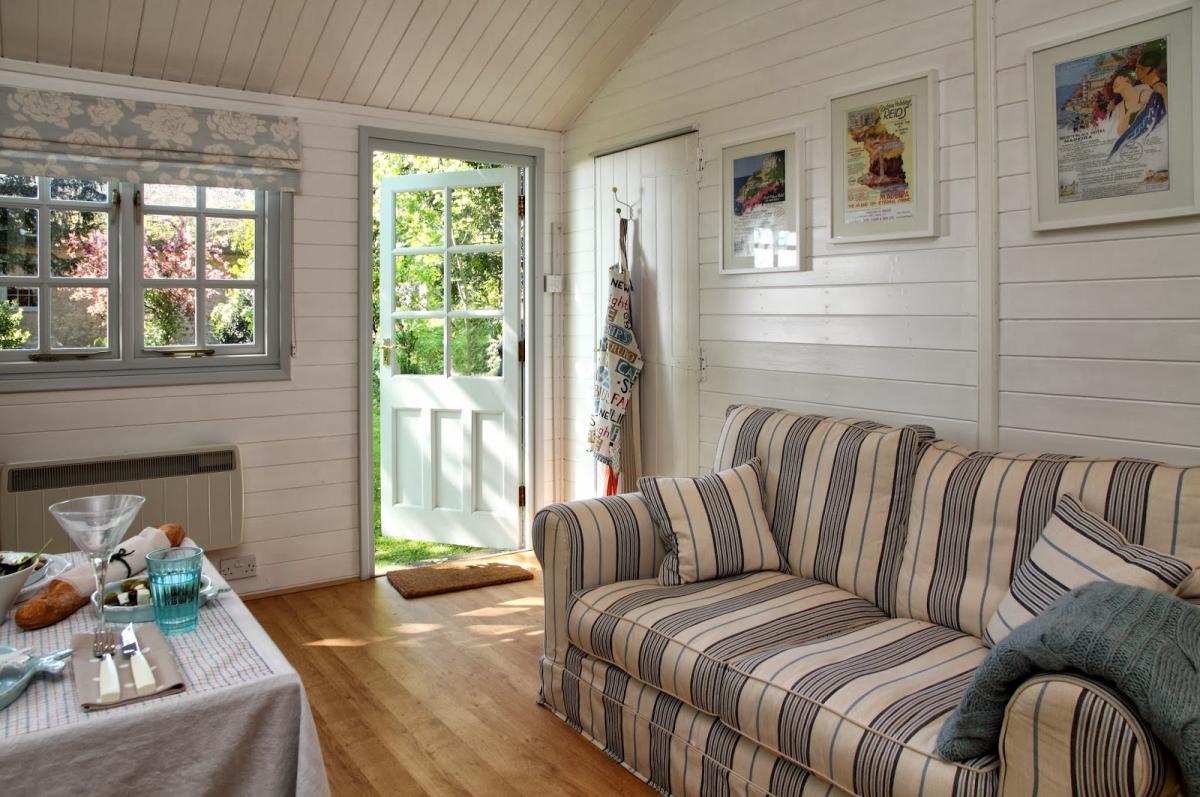 Sofa with striped upholstery in the room of a small country house