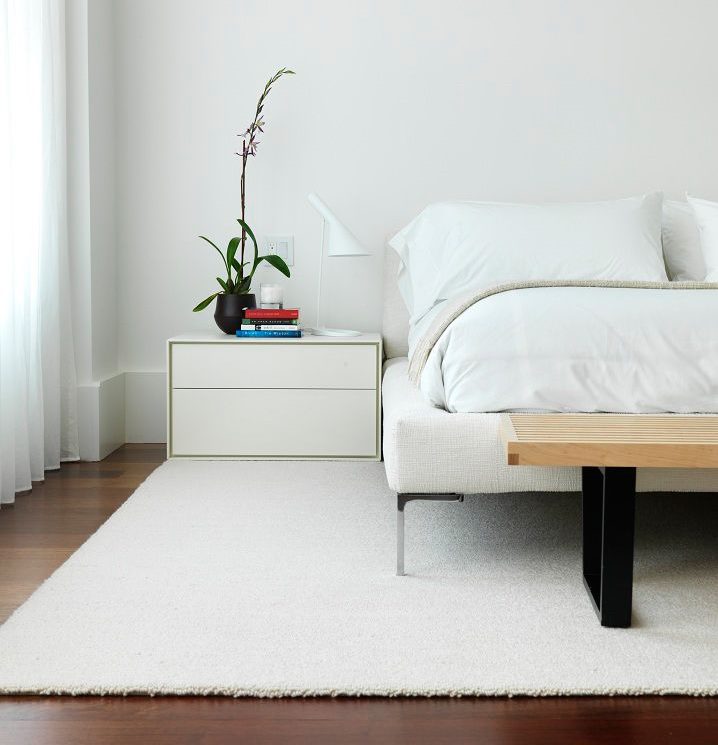 Minimalistički bijeli tepih na podu spavaće sobe