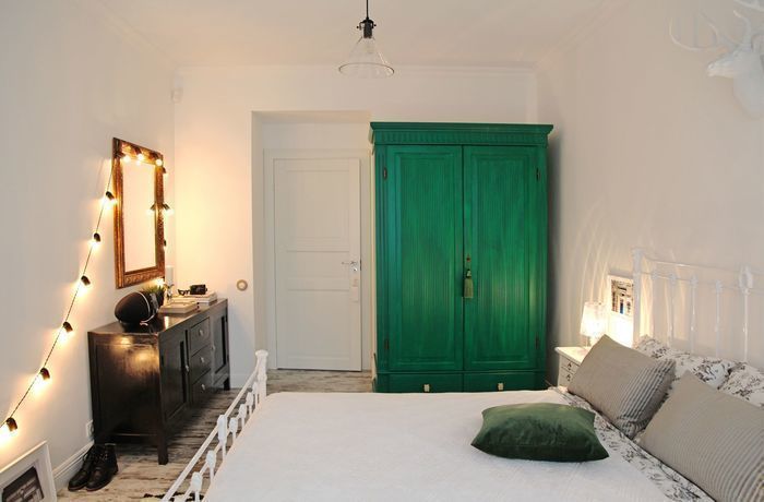 Svijetla unutrašnjost spavaće sobe sa zelenim ormarom