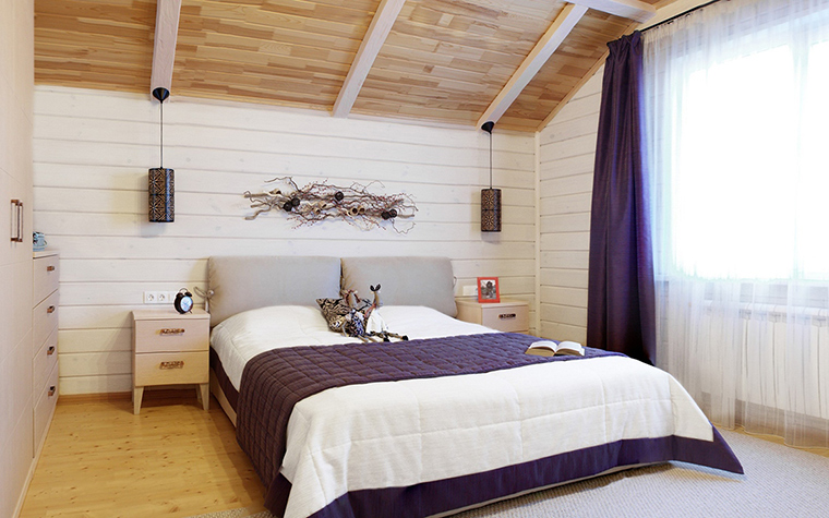 White bedroom interior with dark purple curtains.