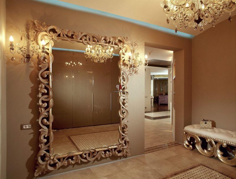 Mirror in a frame with curls on the wall of the hallway