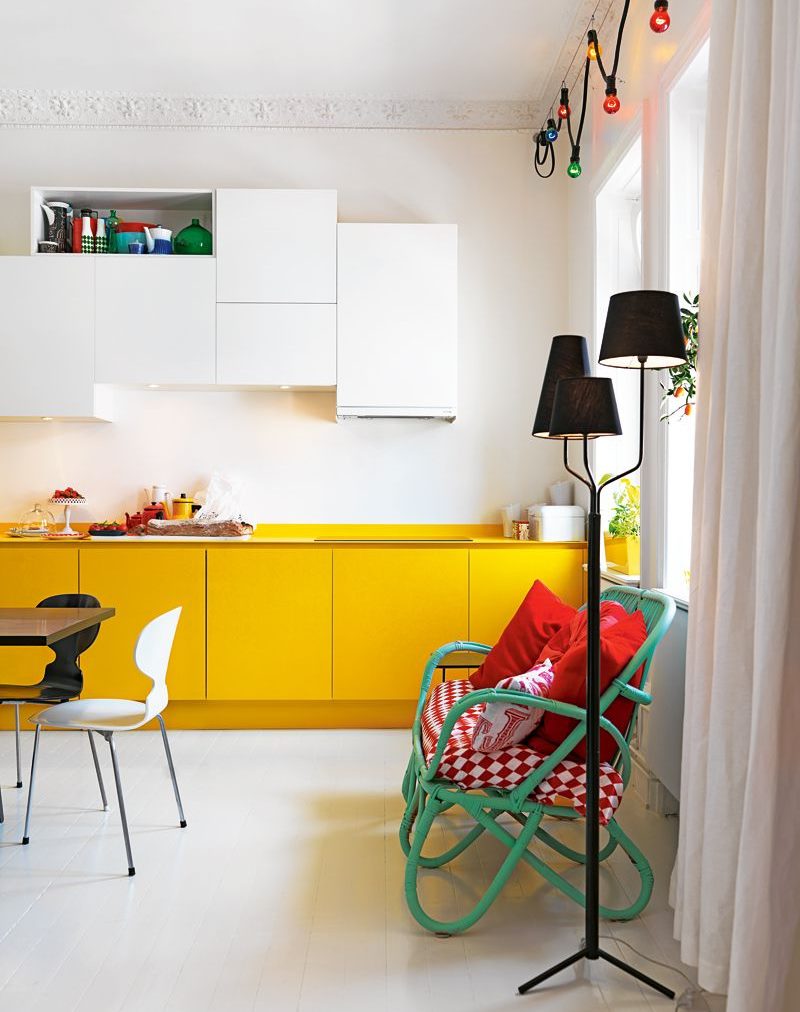 Yellow kitchen cabinets against a white wall