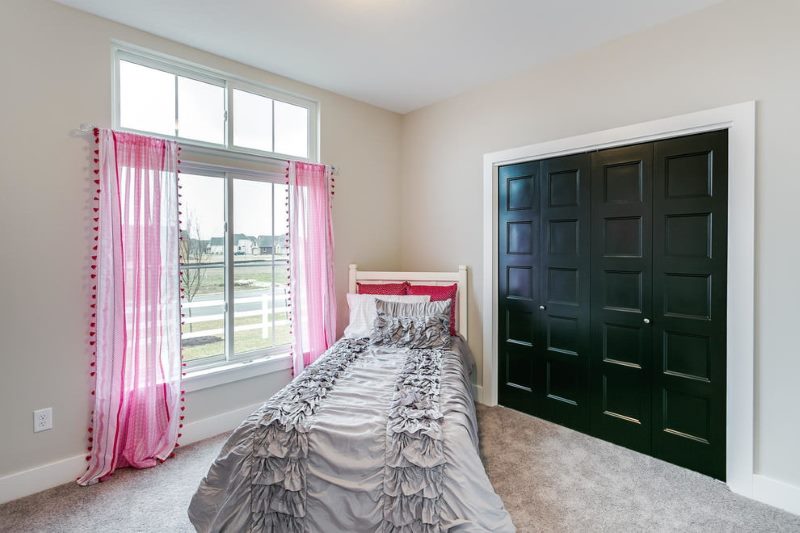 Pink curtains in bedroom with beige floor.