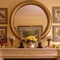 Round mirror on the fireplace portal