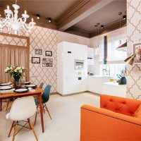 Narančasta fotelja i crvena sofa u kuhinji-dnevnoj sobi