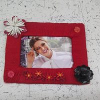 Burgundy threads on a wooden photo frame