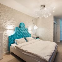 Blue headboard in white bedroom