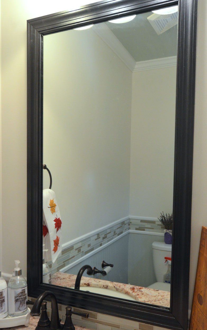 Crni okvir postolja na ogledalu u kupaonici