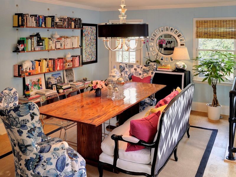 Open shelves with books on the wall of the living room in the style of kitsch.