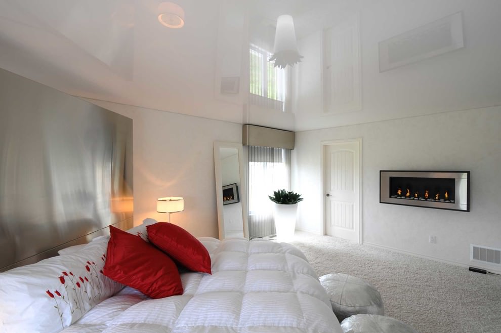 Two red pillows on a white bedspread