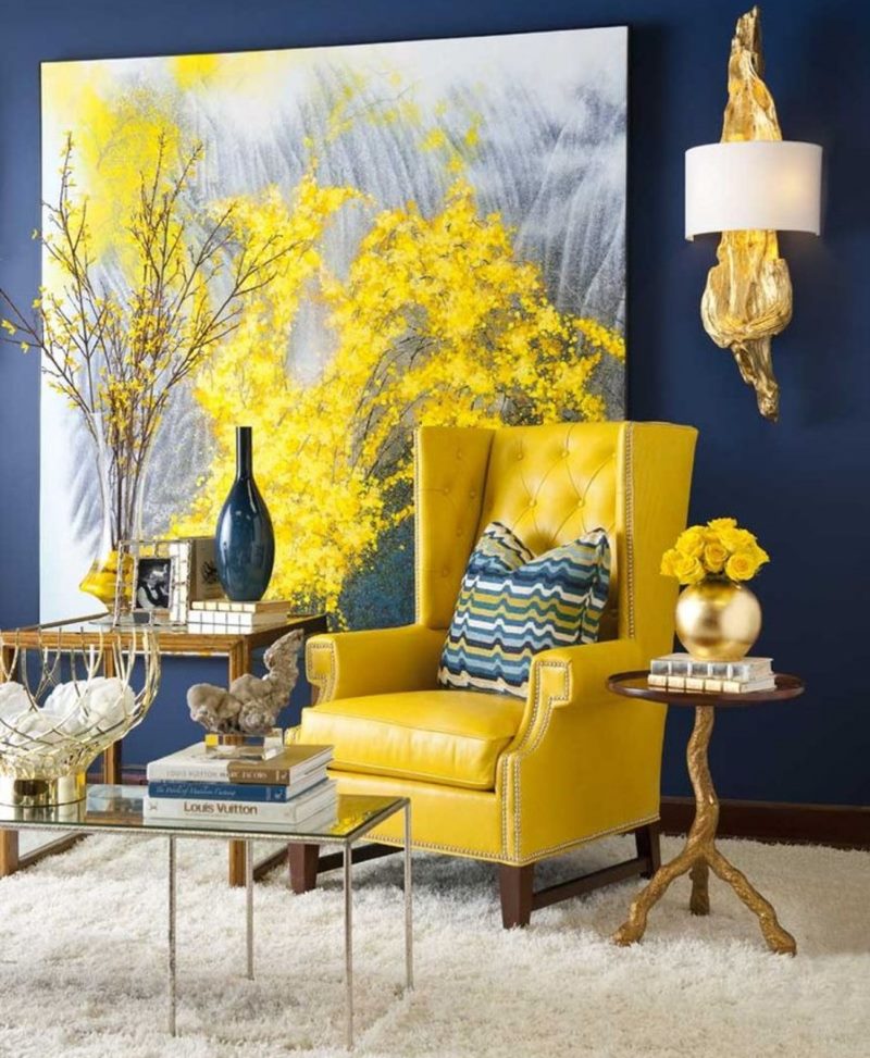 Žuta fotelja na plavom zidu sa slikom