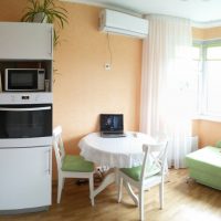 A small dining table in the kitchen of a two-room apartment