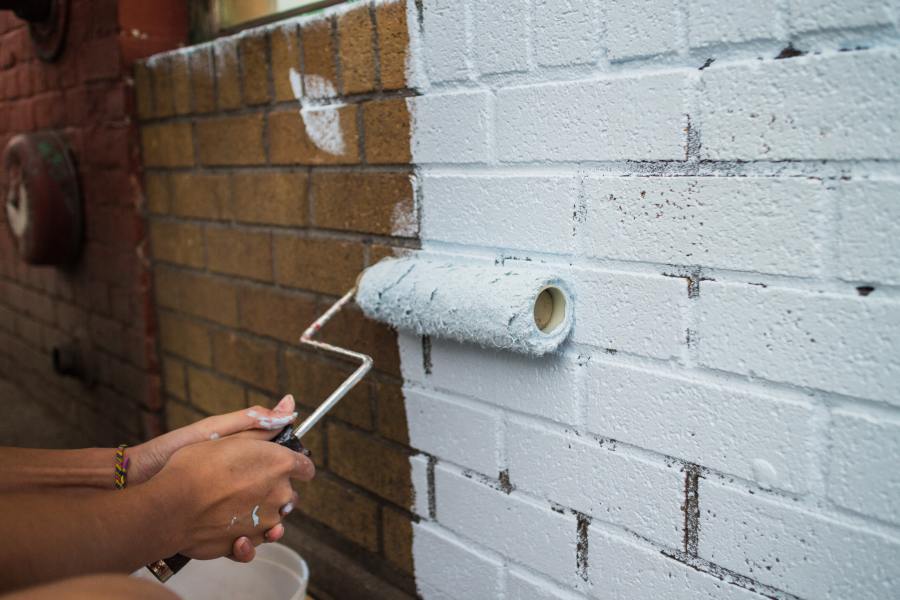 Dipingere un muro di mattoni con un rullo di vernice