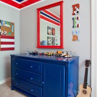 Mirror in a red frame over the dresser in the hallway